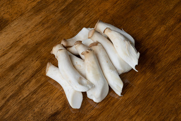 King oyster mushroom Pleurotus eryngii on wooden table. selective focus on some mushroom.