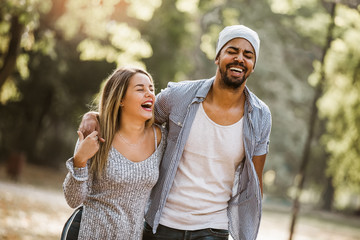 Outdoor portrait of romantic and happy mixed race young couple in park