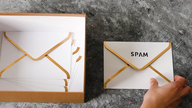 inbox organisation, group of envelopes inside box metaphor of email inbox and hand removing one marked spam outside of it