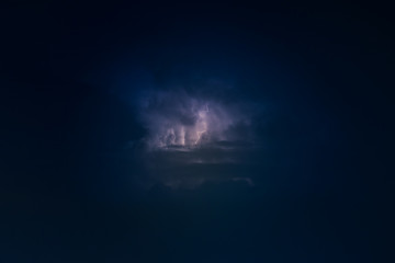Dramatic view of heat lightning storm, thunderbolts and dramatic clouds at night time