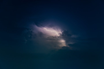 Naklejka na ściany i meble Dramatic view of heat lightning storm, thunderbolts and dramatic clouds at night time