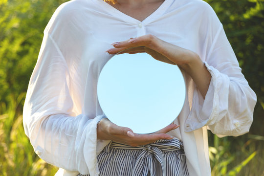 A Round Mirror In The Hands Of A Woman Who Wants To Be Closer To Summer Nature. Trendy Mindfulness Concept.