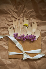 The wooden forks in the envelope are decorated with ribbon and flowers.
