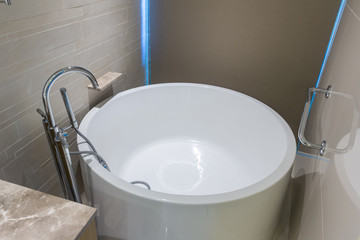 White round bathtub. Modern white house bathroom bathtub. Bathroom interior in cozy colors with modern bathtub. 
