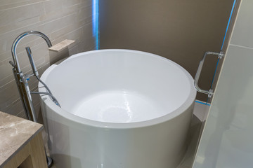 White round bathtub. Modern white house bathroom bathtub. Bathroom interior in cozy colors with modern bathtub. 