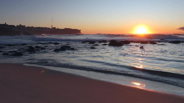 Bronte beach rocks at sunrise swimming people &ndash; 4k.
