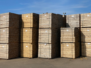 Stacked wooden pallets at wood sawmill and machinery