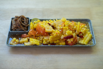 Delicious spicy corn papaya salad served with crispy fish