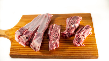 
Mutton ribs, raw, on a wooden cutting board