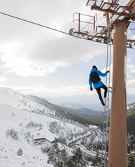 Man climbing stairs of a chairlift in front of amazing views
