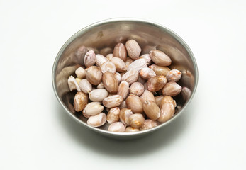 Peanuts in a silver bowl on a white background