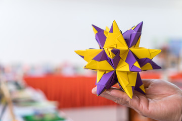 Multicolor modular origami star sphericalal of modular origami spiky ball model on hand, decoration visual art on geometry paper folding and difficult level skills and experience in study at school - obrazy, fototapety, plakaty