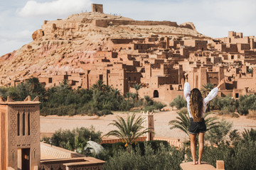 Woman enjoying popular landmark ksar Ait-Ben-Haddou. View from behind. Travel in Morocco, Ouarzazate. Wanderlust concept.