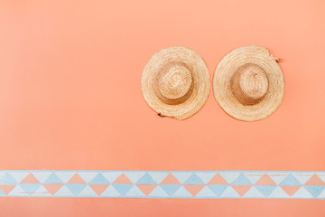 Two wicker straw sombrero hats on background of terracotta color wall in Morocco. Mexican style.