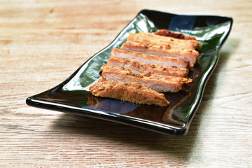 fried slice salty pork sirloin with garlic and pepper on plate