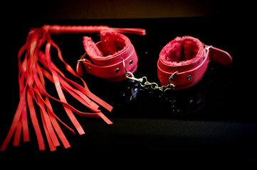 Handcuffs and whip for erotic bondage games