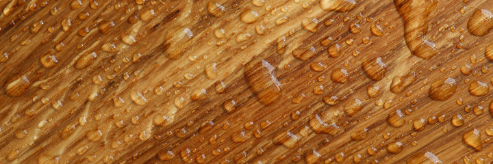 Close-up of wooden surface in drops of water. Wet wood texture. Water drops on polished panel....