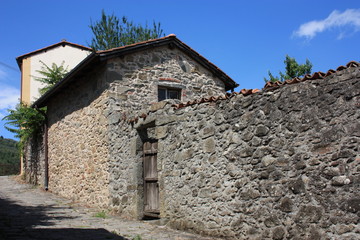 external facade of the stone wall of an ancient stone house in the Tuscan mountains