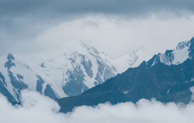 Fototapeta na wymiar Mountain peaks in the clouds, bad weather