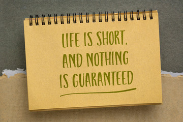 life is short, and nothing is guaranteed - inspirational reminder in spiral sketchbook, enjoy life and don't be afraid to live, personal development concept