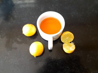 Fototapeta na wymiar Cup of tea and lemon. tea in cup with lemon isolated on black background. lemon tea with lemon. It is a Natural sources of Vitamin C. It increases the immunity of our body. 