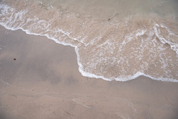 Soft ocean wave on tropical sandy beach in rainy season
