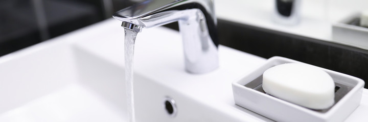 Close-up of bathroom silver crane. Modern bath plumber. Clean and nice home furniture. Water...
