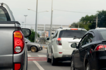 Luxury rear corner of pickup  gray car on the road.  Blurred image of car traffic across the street.
