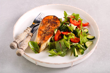 Salmon steak fried served with salad