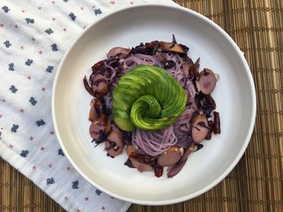 Fried purple rice noodle with sausage and chili mixed garlic and avocado on top
