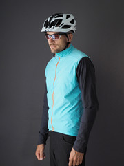 Portrait of a male cyclist in a white helmet, sunglasses and a blue jacket.