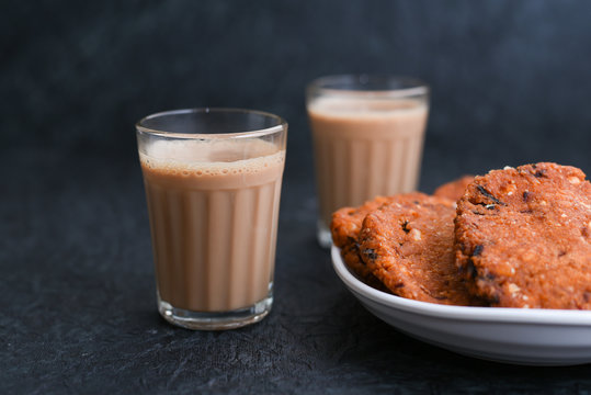 Top view of Indian Masala Chai and Parippu vada traditional milk tea beverage Kerala India. Two cups of organic ayurvedic or herbal drink India, good in winter for immunity boosting.