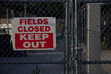 "Field closed" sign blocking access to athletic fields in a city park