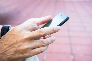 スマートフォンを操作する男性の手　