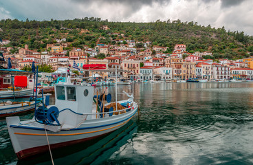 Fototapeta na wymiar Gytheio / Greece - July 17 2017: The port of Gytheio, with fishing boats and view of the town in the background, on a rainy day.