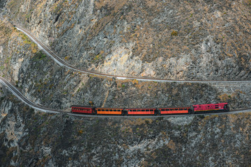 Red train going through the mountain landscape of Chimborazo province, Ecuador