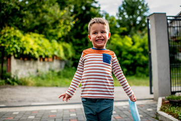 Boy holds out the mask, refuses to take on it on the Playground. The concept of not wearing, refuses to put on masks.