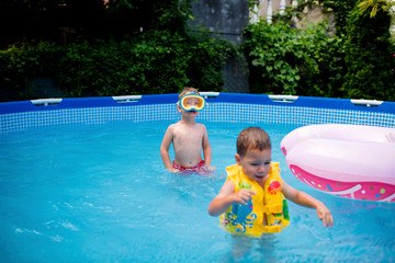 Little boys with having fun in pool at back yard
