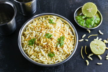 Murmura spicy puffed rice, Jhal Muri, Borugulu and lemon, in Karnataka, India. is a traditional home made Vegan mid-morning snack or cereal breakfast, Indian street food.