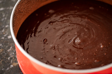 .Raw chocolate cake batter in the form ready to go to the oven. Selective focus.