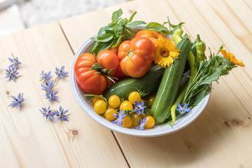 Urban gardening: Fresh cultivated vegetables grown up in the own garden. Tomatoes, zucchini and herbs