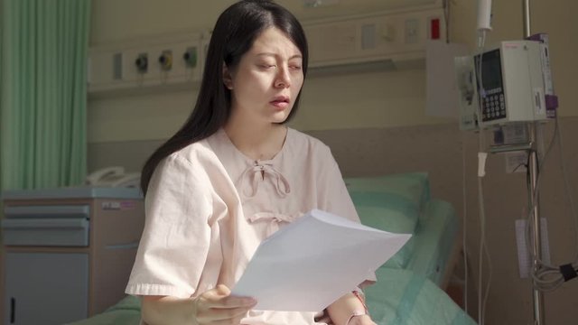 japanese female patient taking glance at the diagnosis and relieve a sigh, looking into distance at a loss. portrait asian woman is upset about getting serious health problem