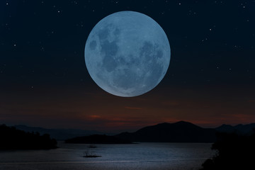 Full moon over lake on the sky.