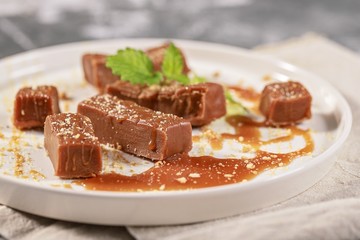 Homemade sweets. Portions of salted caramel on a white plate. Close-up