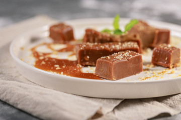 Homemade sweets. Portions of salted caramel on a white plate. Close-up
