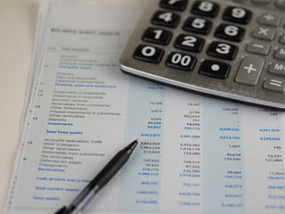 Financial statement concept:Income statement paper sheet with calculator and pen.