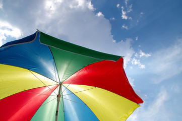 Beach sun parasol on the background of clouds and sky