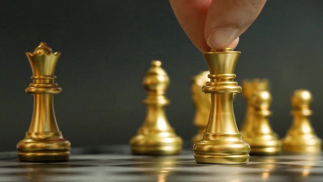 Gold kingis on the movement in chess game on black background (Concept for business decision, first mover, start or beginning project)