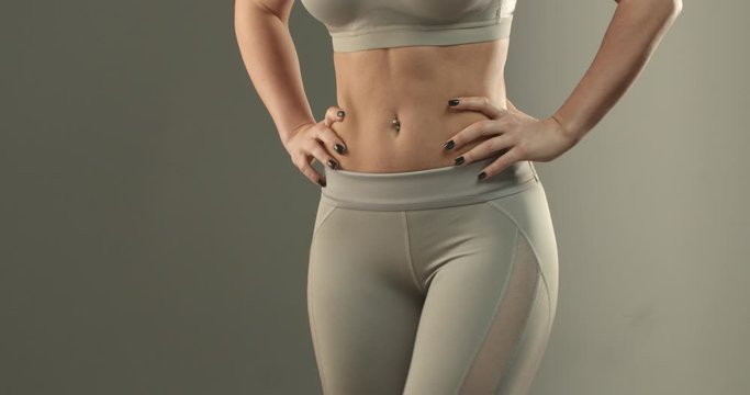 Sports, body shape and fitness concept. Close-up of female abs and bottom. Sportswoman in leggings turning sideways, showing buttocks gluteus and thighs workout progress after gym
