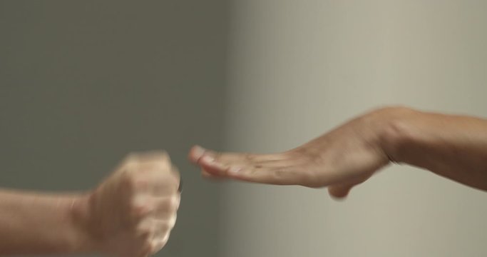 Close-up of male and female hands playing rock paper scissors, woman punch man as he win, fair choosing method who will be first, settling dispute or making decision, concept of teamwork and sports